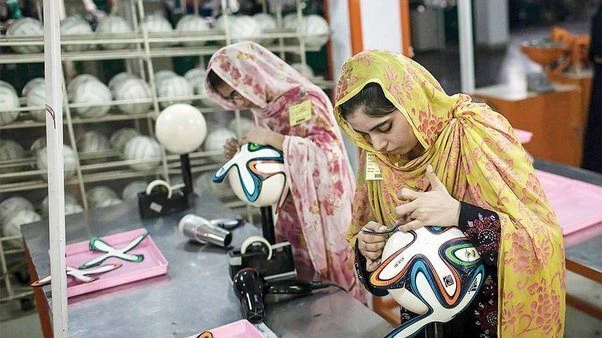 パキスタンの職人がサッカーボールを手縫いしている様子